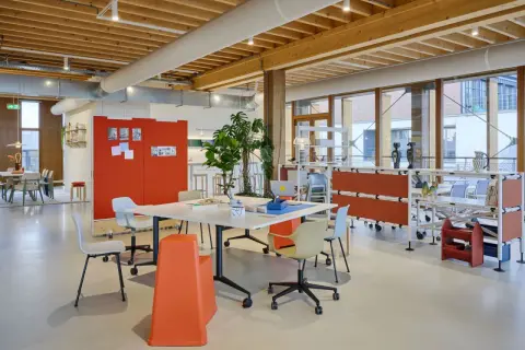 Helles, modernes new work office mit Holzbalkendecke, Besprechungstisch, Pflanzen und flexiblen Trennwänden.