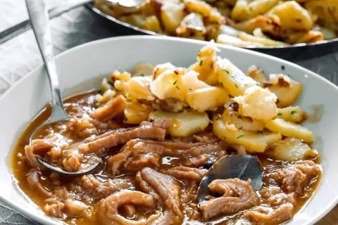 Herzhaftes Kutteln Rezept mit goldbraunen Bratkartoffeln, garniert mit Petersilie. Ein Löffel voller Genuss.