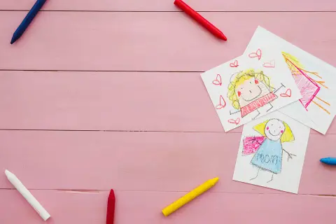Dziecięce rysunki mamy i dziecka, kredki. Obrazek symbolizuje troskę i wsparcie, jak alimenty na dziecko.
