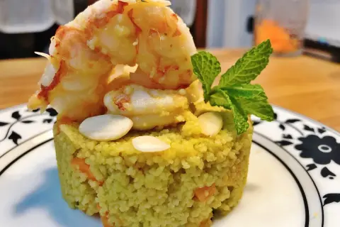 Un elegante cous cous gourmet con gamberi, mandorle e menta, un piatto raffinato.