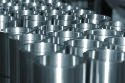 Rzędy metalowych pierścieni, efekt obróbki plastycznej metalu na zimno. Błyszczące powierzchnie odbijają światło.