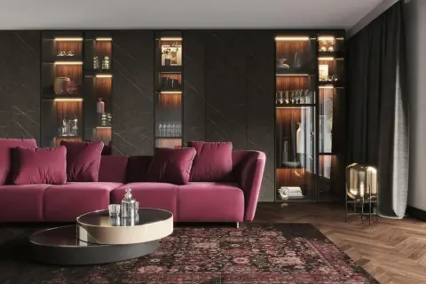Elegancki salon z sofą w kolorze fuksji i dywanem w stylu art deco malarstwo. Podświetlane witryny pełne szkła i dekoracji.