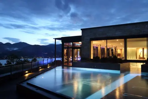 Ein luxuriöser Pool mit Blick auf die Berge und einen See. Perfekt für einen entspannten Urlaub in den Bergen.