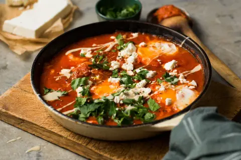 En smakrik shakshuka med ägg, tomat och fetaost, perfekt för en mysig frukost eller brunch.