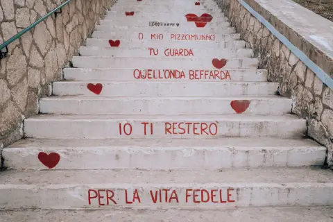 Scale a Vieste con cuori rossi e frasi d'amore dipinte. "O mio Pizzomunno, tu guarda quell'onda beffarda, io ti resterò per la vita fedele.