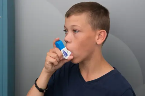 Pojke använder inhalator. Tänk på att vape farligt kan påverka lungorna.