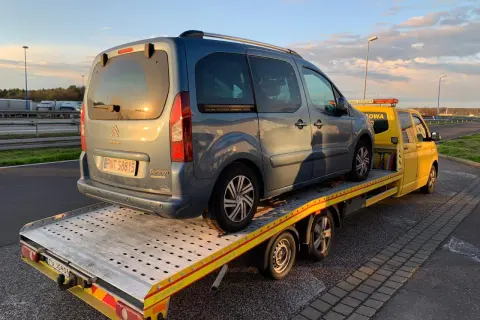 Niebieski Citroen Berlingo na żółtej lawecie. Pomoc drogowa HDI assistance w akcji, holowanie pojazdu po awarii.