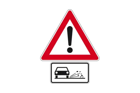 Achtung! Zeichen 265 warnt vor Steinschlag. Ein Auto fährt über lose Steine, die aufgewirbelt werden.