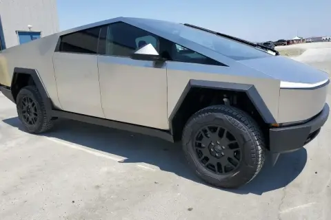 Futurystyczny Tesla Cybertruck na tle betonowego placu. Zastanawiasz się nad jego ceną?