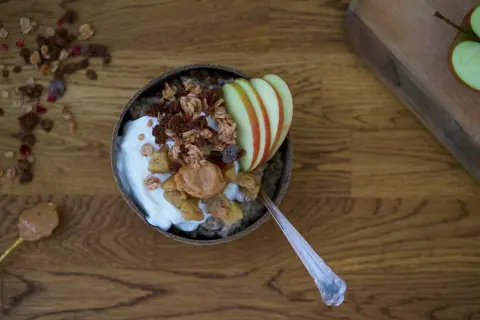En skål med chiapudding och kvarg, toppad med granola, äpple och jordnötssmör. En perfekt frukost!
