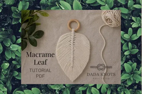 Décoration murale en macramé aux couleurs vives, avec des cordes torsadées formant des feuilles.