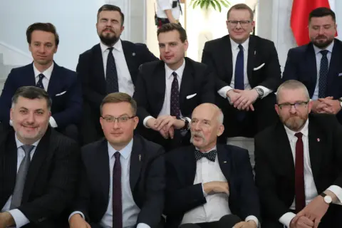 Grupa mężczyzn w garniturach, być może symbolizująca ruch narodowy a wolnościowcy starcie frakcji wewnątrz Konfederacji.