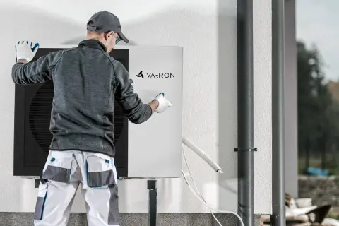 Técnico revisa unidad de aerotermia Vaeron, asegurando el correcto desescarche para óptimo funcionamiento.