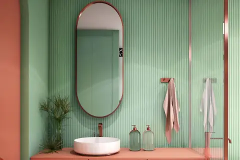 Bagno moderno con pareti verdi a coste e arredi color corallo. Ottime idee rivestimento bagno piccolo con specchio ovale e lavabo a ciotola.