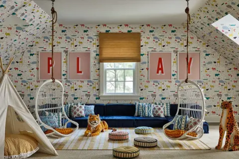 A whimsical playroom set up with animal wallpaper, hanging chairs, a teepee, and plush toys.