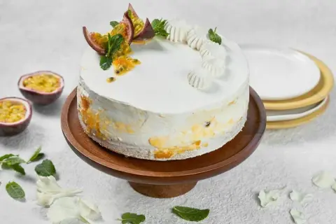 En vacker vegansk tårta med passionsfrukt och mynta, dekorerad med små maränger.