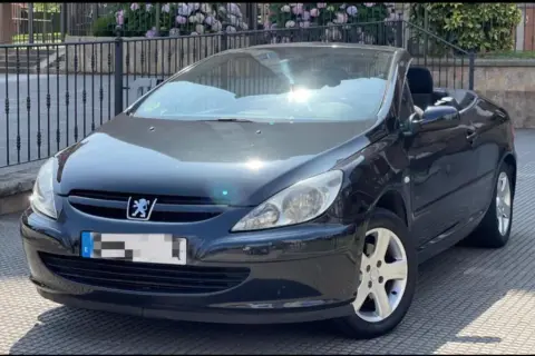 Svart Peugeot 307 CC cabriolet med taket nere. Solen reflekteras i vindrutan, kanske ett tecken på ett kommande peugeot 307 cc problem?