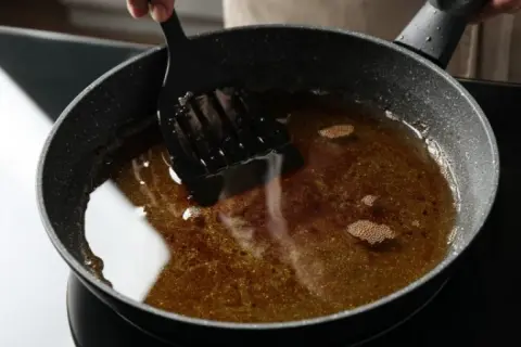 Zastanawiasz się, ile razy można smażyć frytki na tym samym oleju? Ten ciemny, mętny olej w patelni sugeruje, że był już wielokrotnie używany.