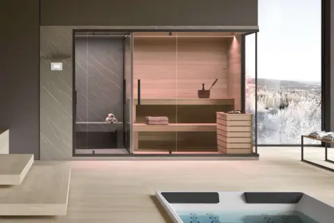 Un lussuoso mini spa in casa con sauna e doccia, affacciato su un paesaggio invernale innevato.