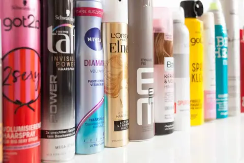 Reihe von Haarspray-Dosen, darunter "got2b 2sexy" und "NIVEA DIAMANT", ideal für Haarspray auf nasse Haare.