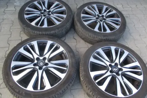 Cztery felgi aluminiowe Renault Initiale z oponami, gotowe do montażu.