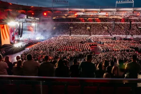 Ein riesiges Publikum feiert bei einem Teddy Show Konzert in der MHP Arena Stuttgart. Die Bühne erstrahlt in bunten Lichtern.