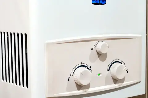 Ein weißer Durchlauferhitzer mit Reglern und Lüftungsschlitzen, bereit zum Entkalken.