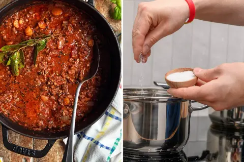 En gryta med köttfärssås och en hand som saltar en kastrull. Om du undrar hur man får bort salt smak, kan det vara bra att veta att man kan späda ut maten.