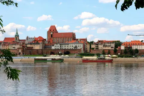 Widok na zabytkowe Stare Miasto Toruń z Wisłą i statkami wycieczkowymi. Tak wygląda Toruń.