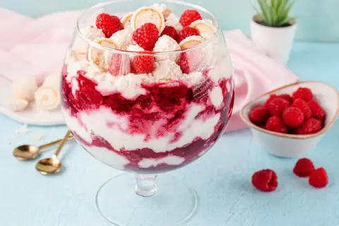 Raffaello Himbeer Dessert im Glas mit frischen Himbeeren und Kokosflocken.