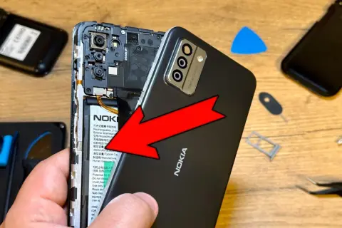 Wymiana baterii w telefonie Nokia. Czy przy wymianie baterii resetuje telefon? Narzędzia do naprawy leżą obok.