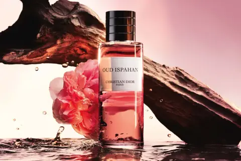 Flakon Dior Oud Ispahan otoczony wodą, różą i fragmentem drewna.