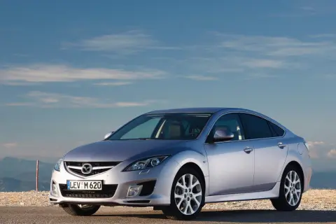 Srebrna Mazda 6 na tle błękitnego nieba. Wiele osób szuka mazda 6 opinie przed zakupem.