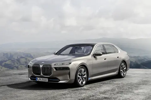 Elegancki, szary sedan BMW 7 2025 na tle górskiego krajobrazu.