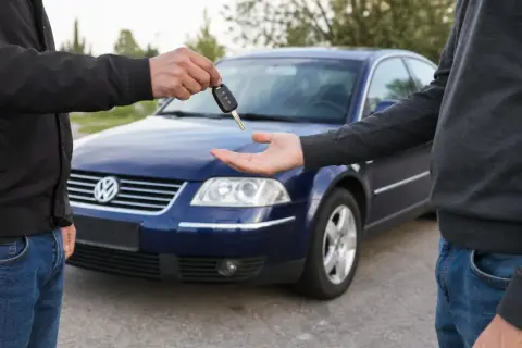 Przekazanie kluczyków do niebieskiego Volkswagena. Dowiedz się, jak zgłosić sprzedaż samochodu i dopełnić formalności.