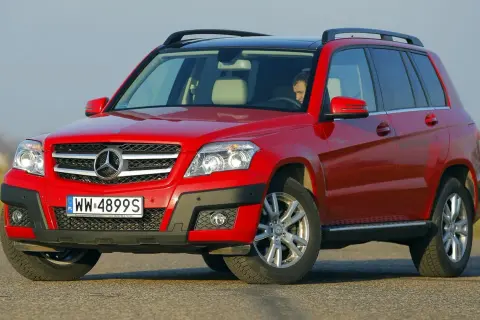 Czerwony Mercedes GLK na drodze. Kierowca w środku. Wiele osób szuka mercedes glk opinie przed zakupem.