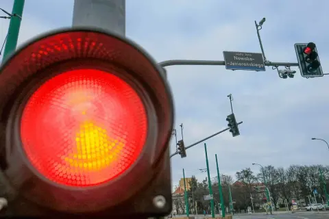 Czerwone światło na sygnalizatorze drogowym, a obok niego fotoradar na światłach. Uważaj, bo możesz dostać mandat.