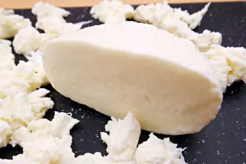 Kawałek mozzarelli light, otoczony postrzępionymi kawałkami sera. Idealna do lekkich sałatek, niskokaloryczna przyjemność.