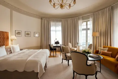 Ett elegant rum på Clarion Hotel Östermalm med en stor säng, soffa, skrivbord och vackra gardiner.