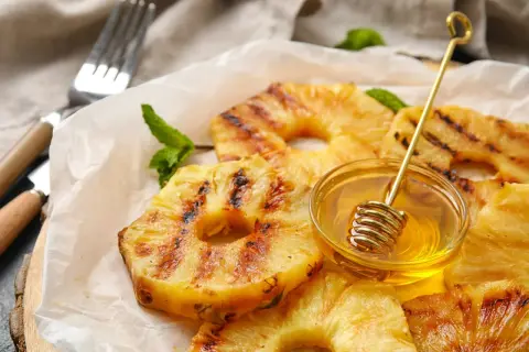 Złocisty, grillowany ananas z miodem i miętą, gotowy do podania.