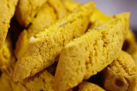 Närbild på gyllene saffransbiscotti med mandel, perfekta att doppa i kaffe.