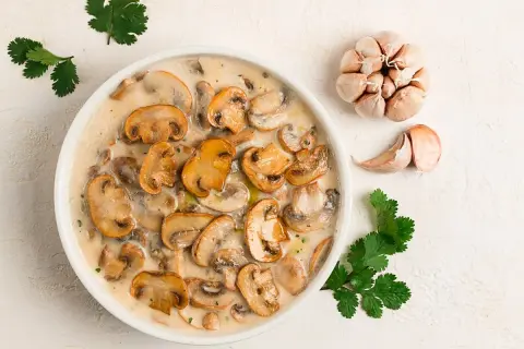 Krämig svampgryta, perfekt för ett snabbt champinjoner recept. Serveras med vitlök och färsk koriander.