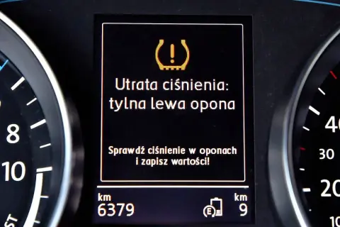 Komunikat na desce rozdzielczej: "Utrata ciśnienia: tylna lewa opona". Czujnik ciśnienia w oponach sygnalizuje problem.