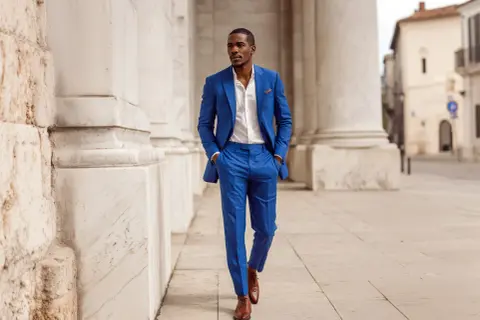 Uomo con abito blu elegante, camicia bianca e scarpe marroni. Un look perfetto per ogni occasione.