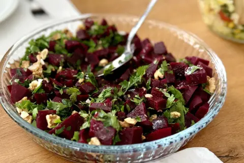 Pyszna sałatka gruzińska z buraków, orzechów włoskich i świeżej pietruszki w szklanej misie.