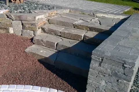 Kamienne schody i murek z kamienia łupanego tworzą naturalny element ogrodu.