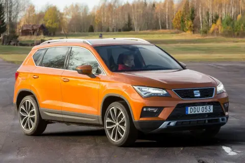 Orange Seat Ateca på en grusväg, redo för ett test. En förare sitter bakom ratten.