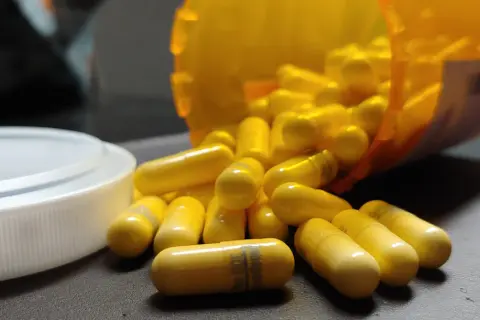 Gula kapslar, en del av en burk, ligger utspridda. En kapsel visar texten "gabapentin 300 mg", en medicin som kan hjälpa mot ångest.