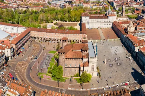 Vista aerea di **Piazza Castello a Torino**, con il Palazzo Reale e la Mole Antonelliana sullo sfondo.