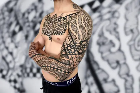 Mann mit beeindruckendem Unterarm Tattoo, das seine Familie symbolisiert.